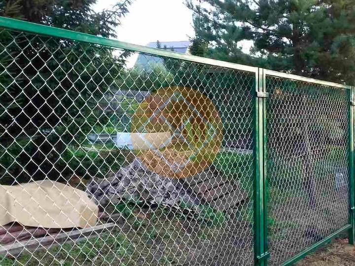 забор из сетки рабицы с зелеными опорными столбами для дачи